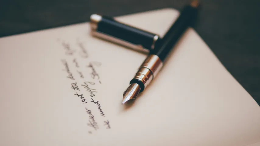 Closeup photo of a fountain pen resting on top of an notebook