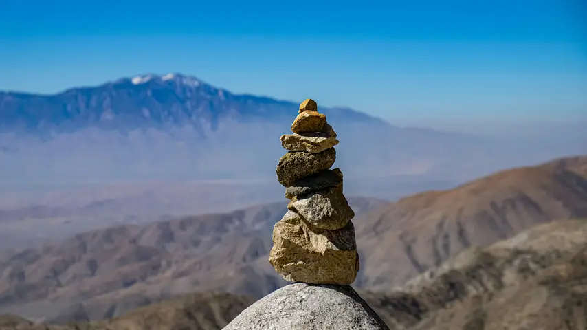 Stone stack with mountains in background at Joshua Tree National Park