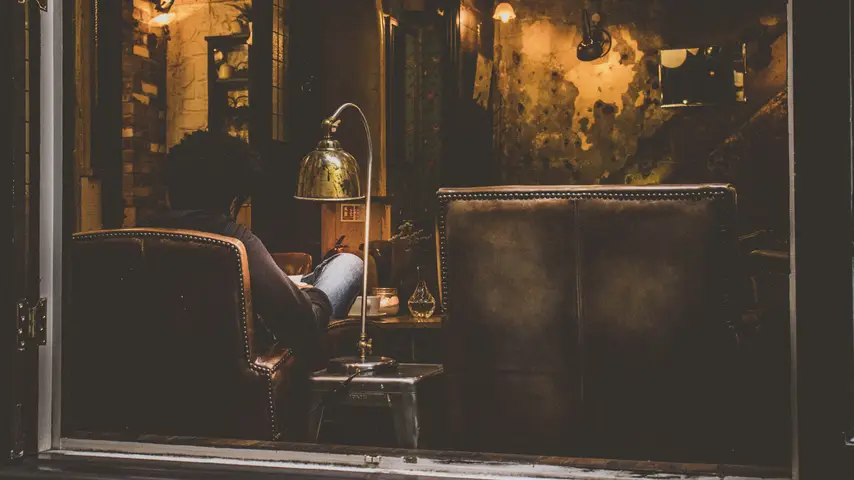 A man reading in a chair in a coffee shop in Cardiff, Wales