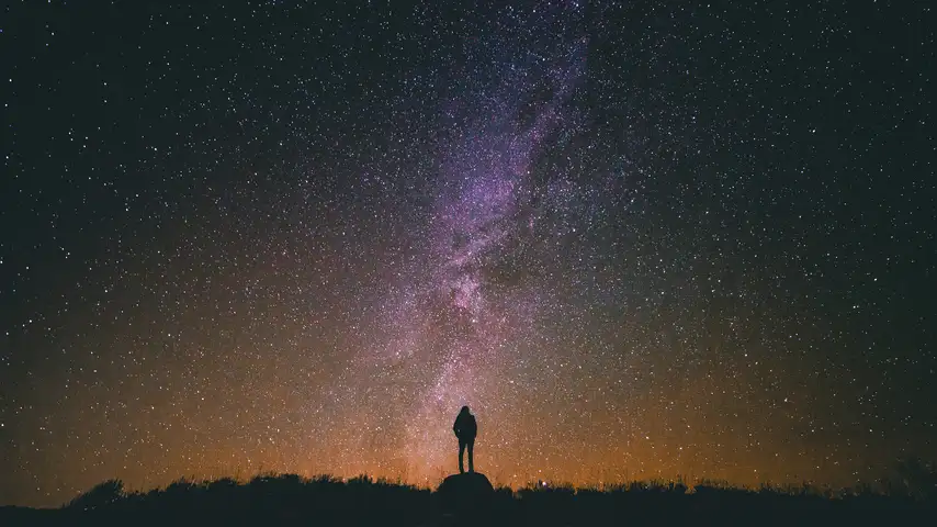 photo of man looking into nighttime sky