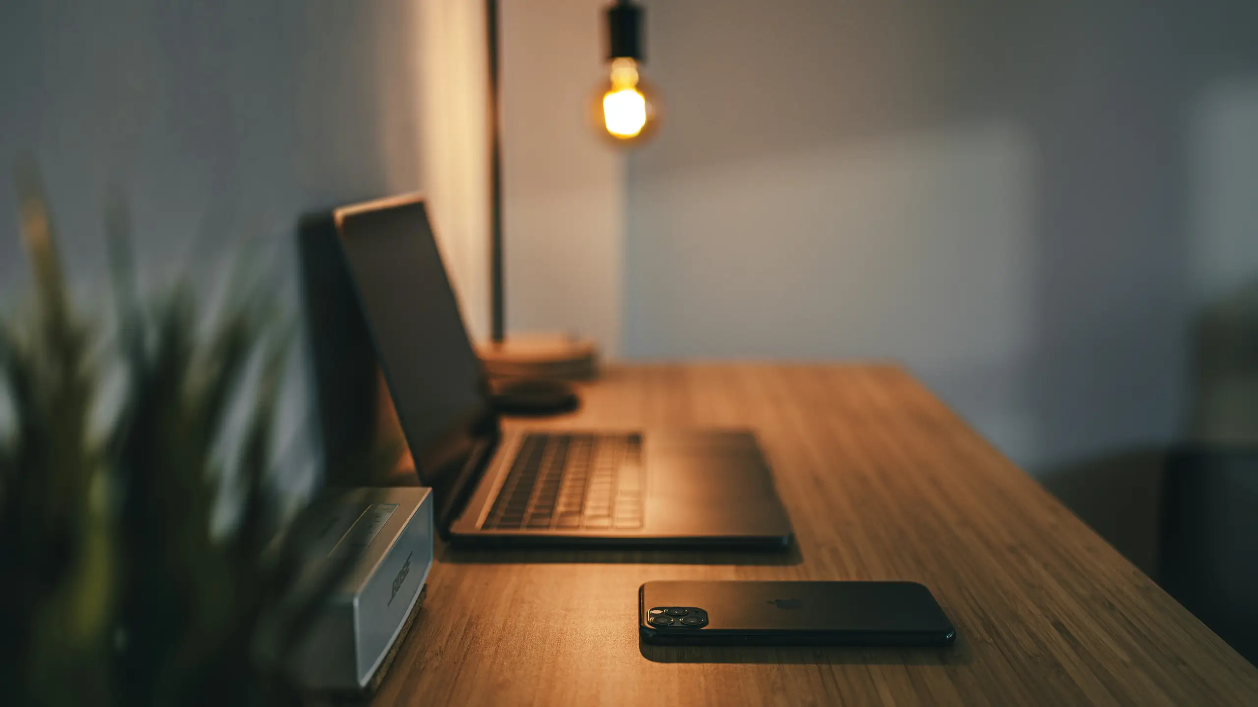 Photo of a desk on which rests a laptop and cell phone