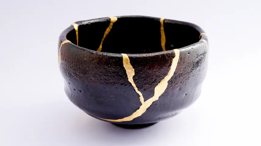 Black raku chawan bowl repaired using the Kintsugi technique, an ancient Japanese practice.