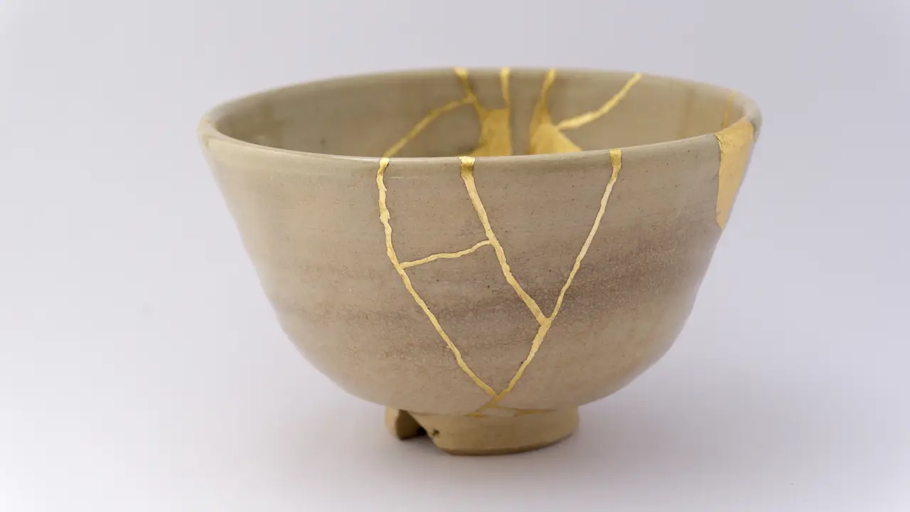 Beige Japanese tea ware that was repaired using the kintsugi technique. The result is a unique piece of art even more beautiful than the original.