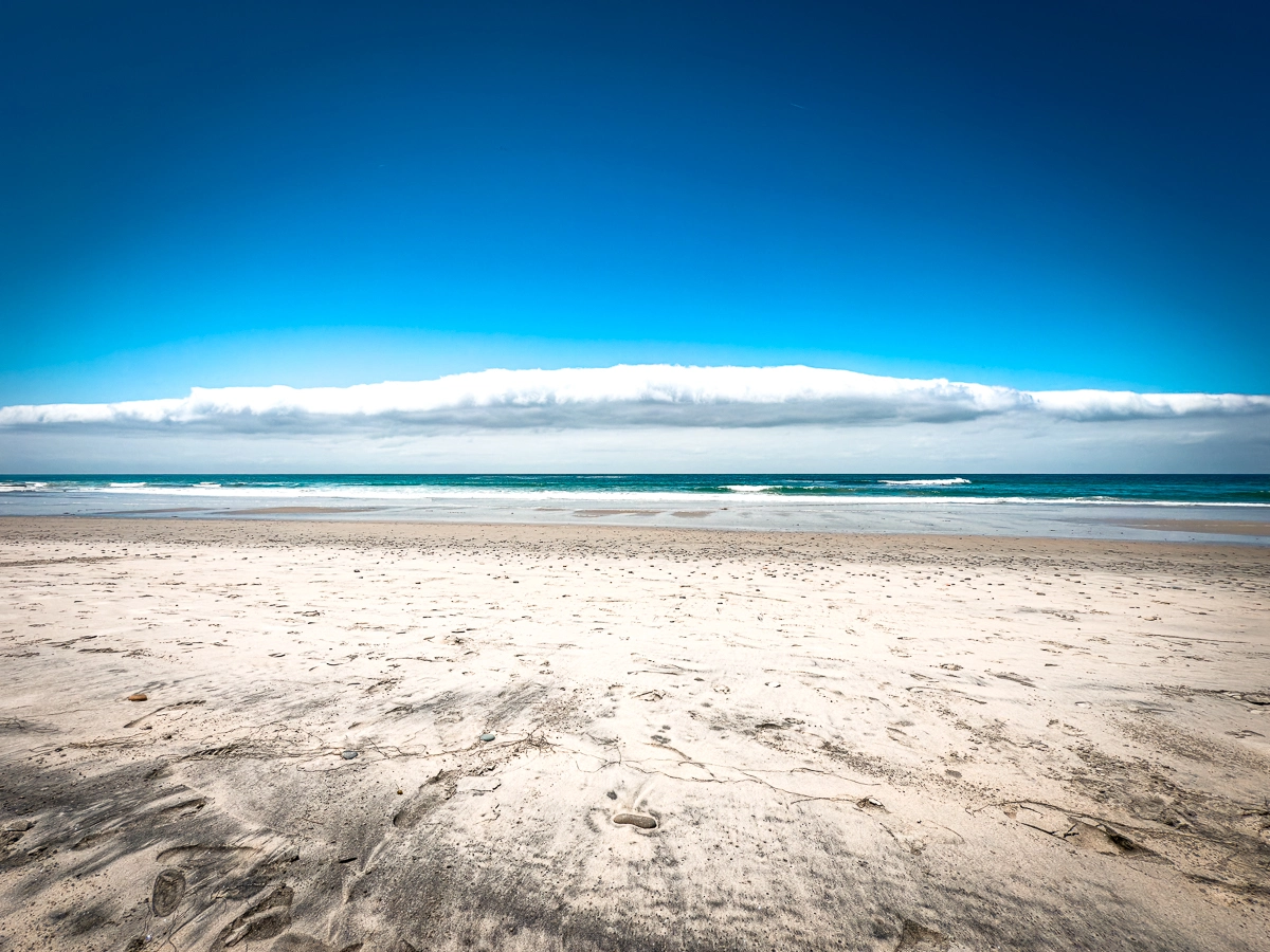 Sandy beach on a sunny day with the Pacific Ocean in the background
